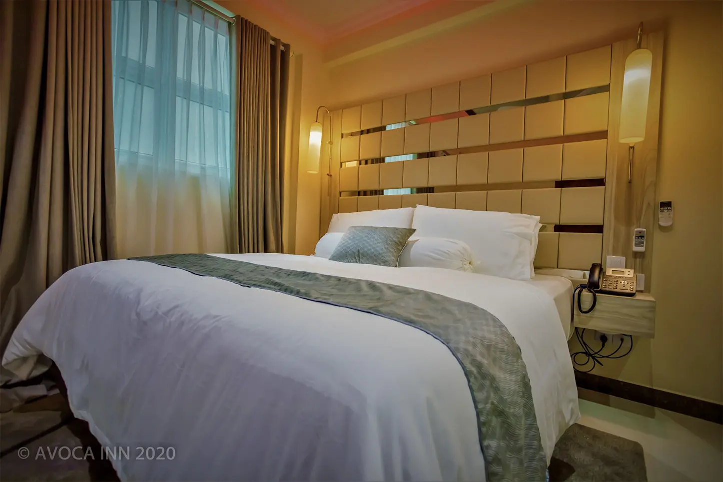 Avoca Inn: A cozy hotel room features a king-size bed with soft lighting and elegant decor.