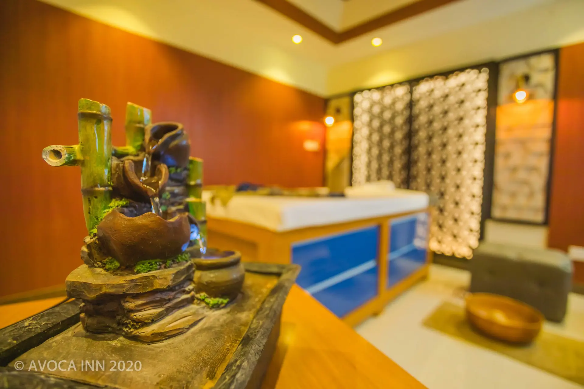 A relaxing spa room features a decorative bamboo fountain and massage bed, promising ultimate tranquility.